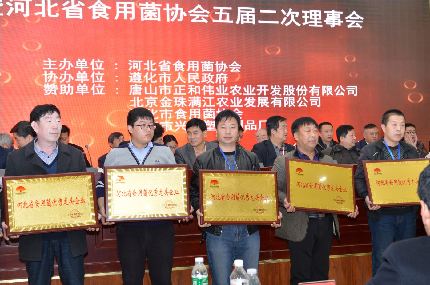遵化市億昌食用菌科技有限公司被授予&ldquo;河北省食用菌產(chǎn)業(yè)扶貧突出貢獻單位&rdquo;榮譽，張東平（中）接授牌匾（截屏）.JPG
